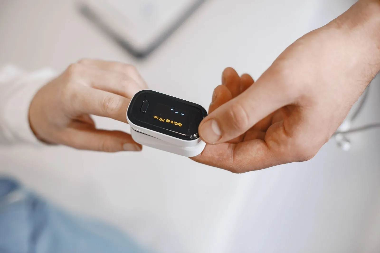 En person sätter en fingeroximeter på någon annans finger
