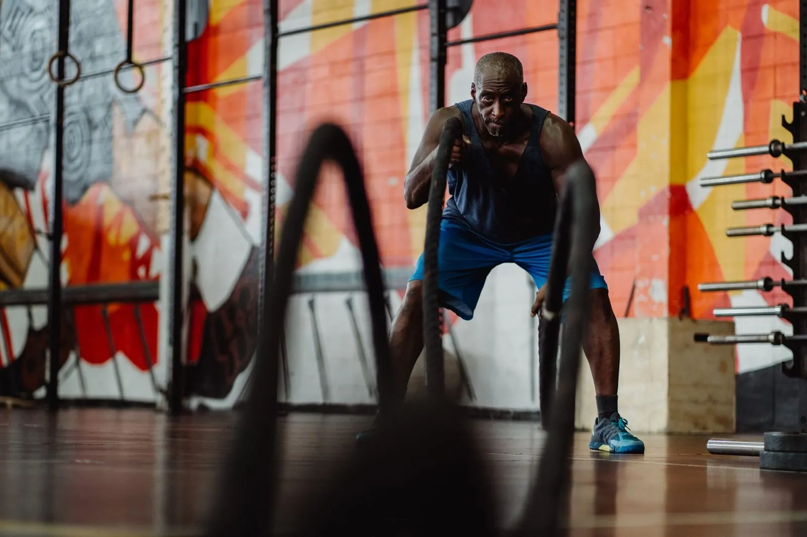 Man tränar med battle ropes på ett gym.