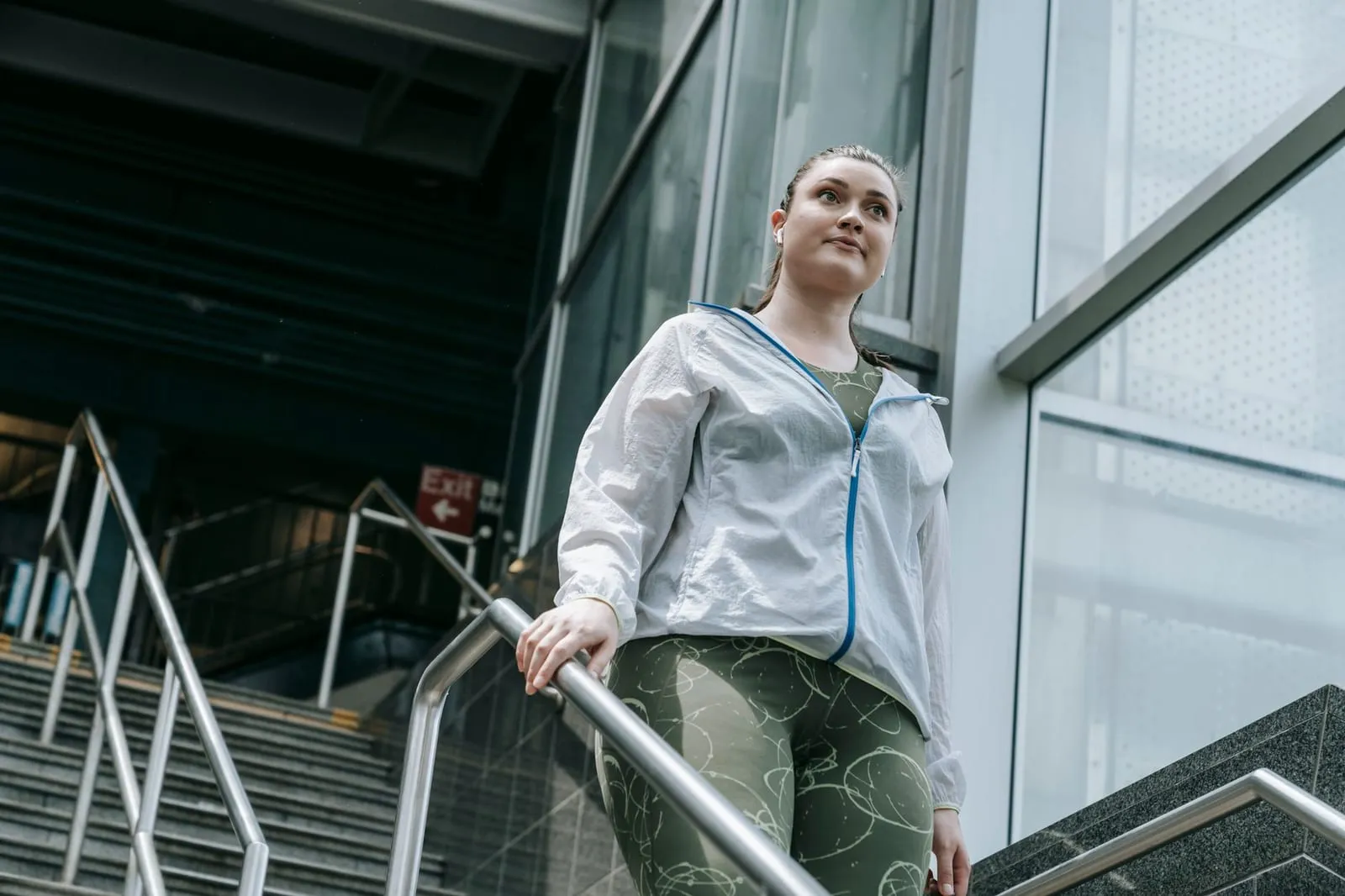 Kvinna i träningskläder går nerför en trappa.